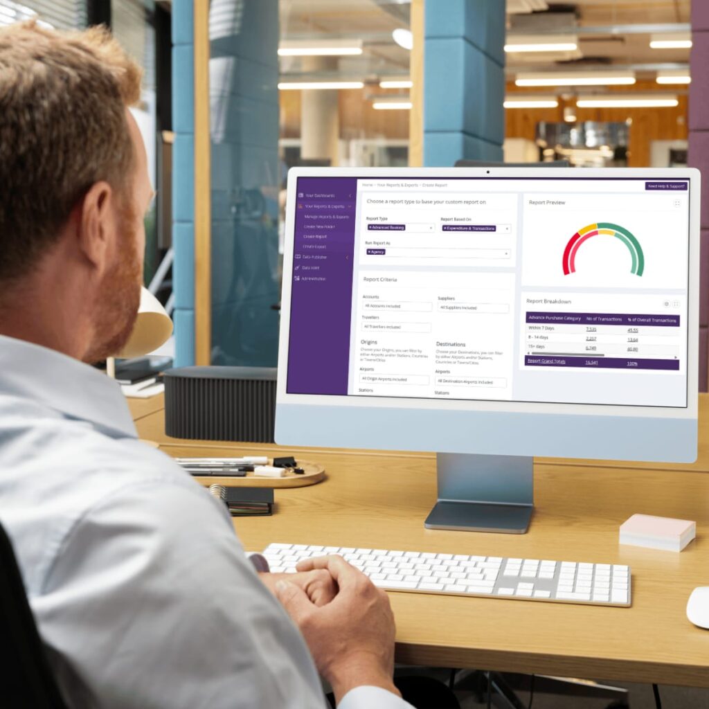 Man at desk looking at a computer monitor with data tables and graphs on the screen